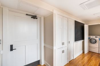A laundry room with white cabinets and a washing machine